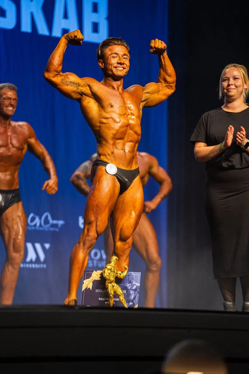Alex Lu fejrer DM-guld i classic physique 2025 med pokalen på scenen